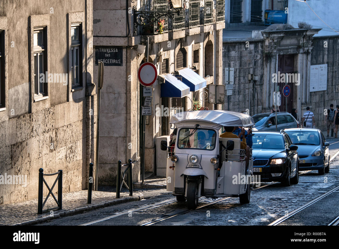 Tourists being driven through the streets of the Alfama district in a rickshaw, tuk tuk,  Lisbon, Portugal. Stock Photo