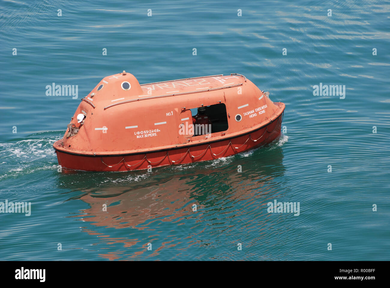 Ship's Totally Enclosed Lifeboat at Sea Underway Stock Photo