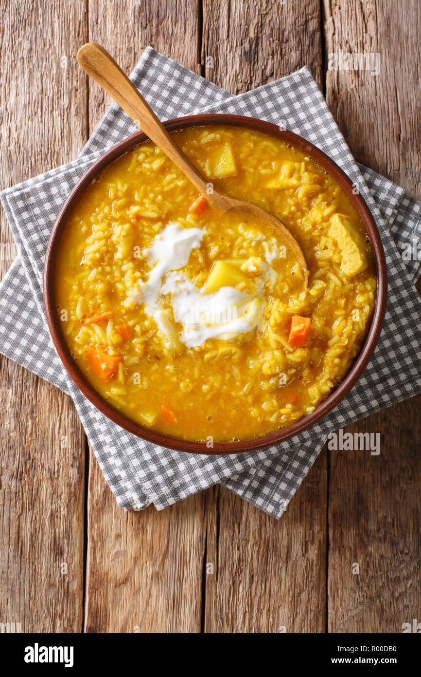 Delicious Tamil Mulligatawny soup with lentils, rice, chicken, vegetables and apple closeup in a bowl on the table. Vertical top view from above Stock Photo