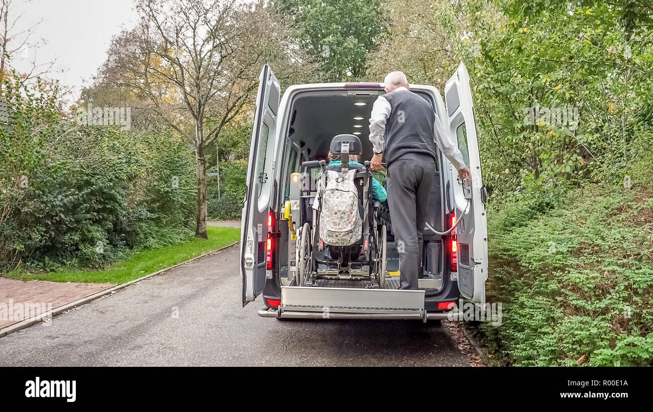 A senior retired man helping to transport disabled people Stock Photo