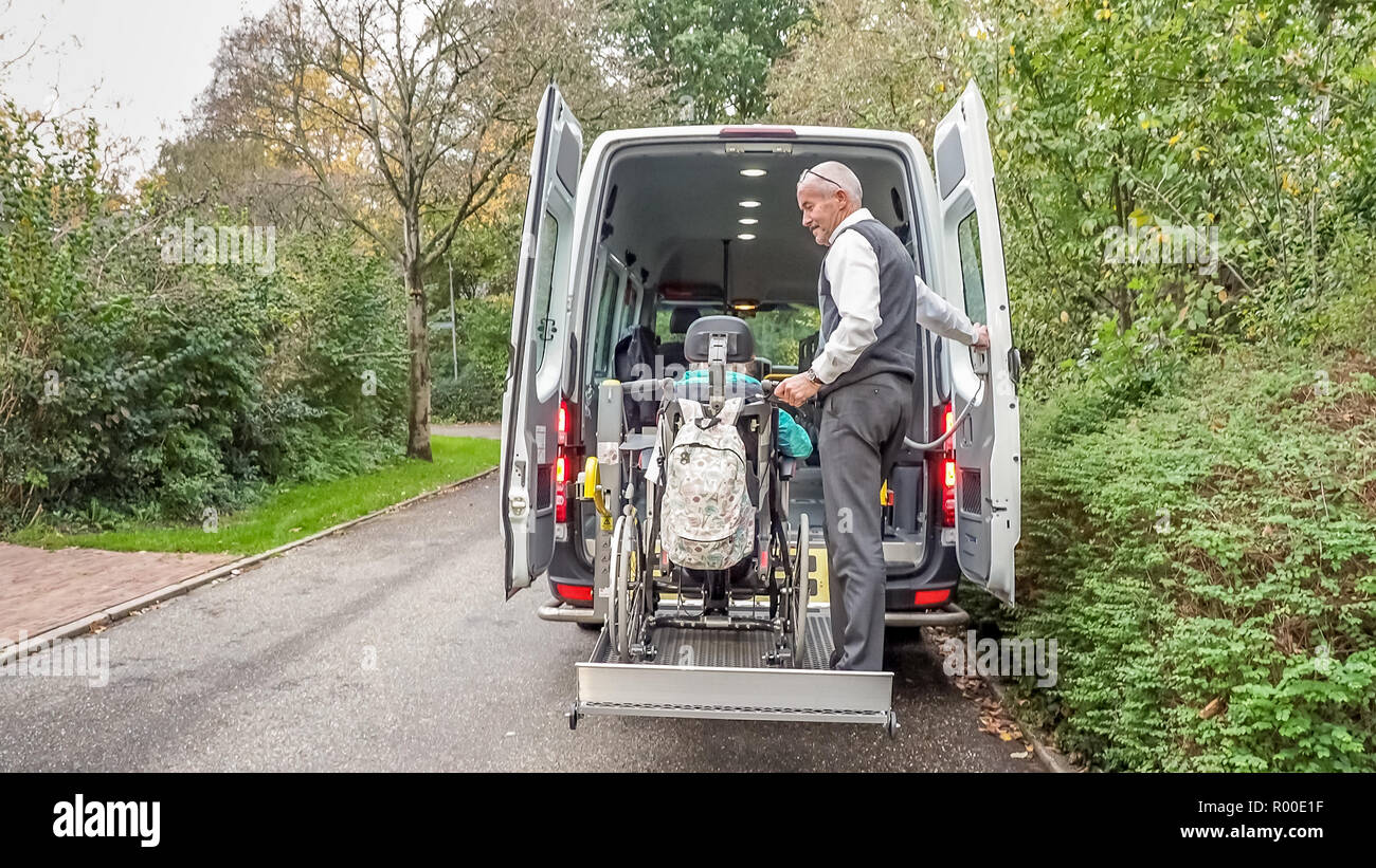 A senior retired man helping to transport disabled people Stock Photo