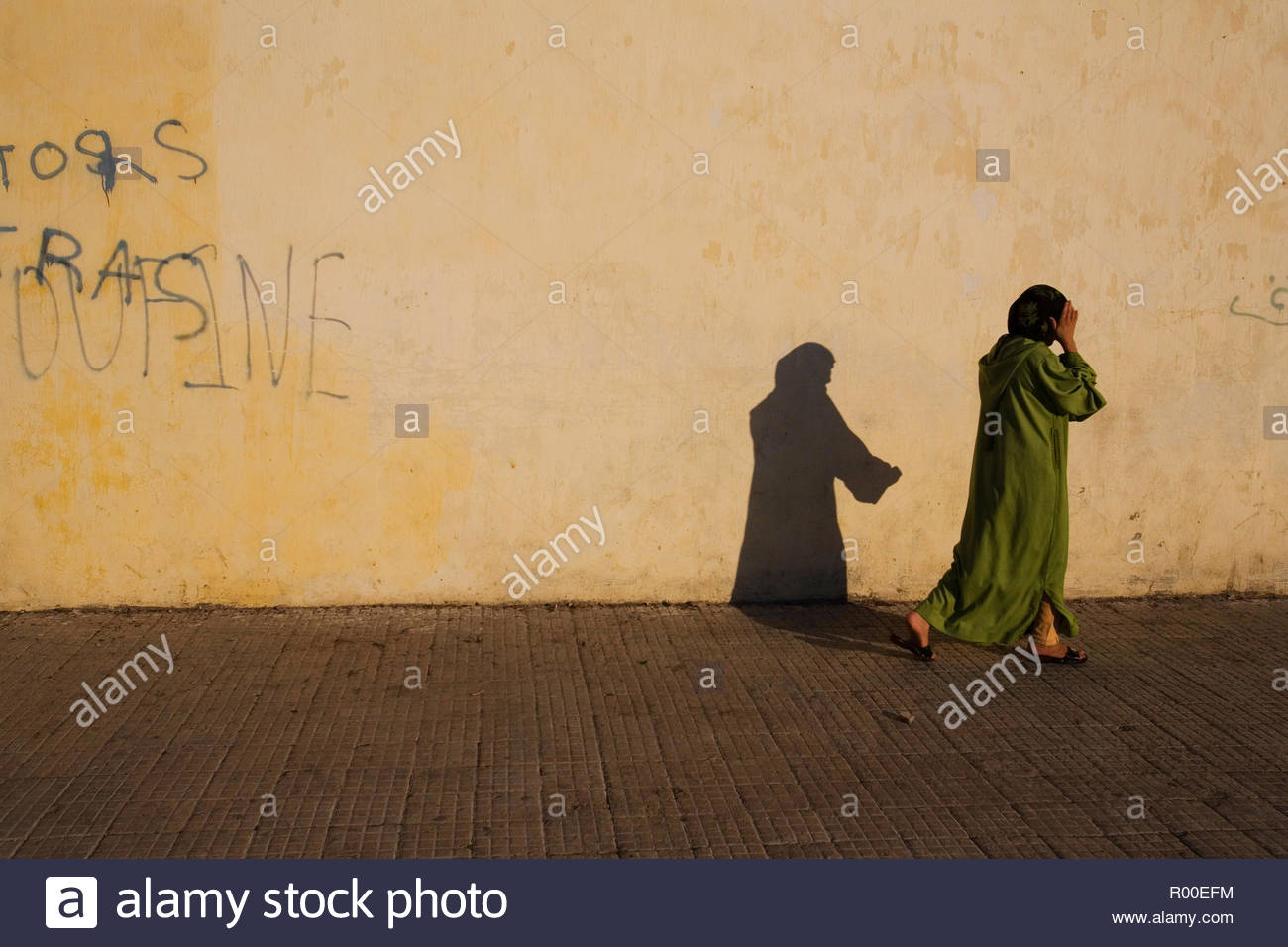 A Woman Walking Casting Her Shadow Of A Flowing Robe In The Early Evening Golden Light Stock Photo Alamy