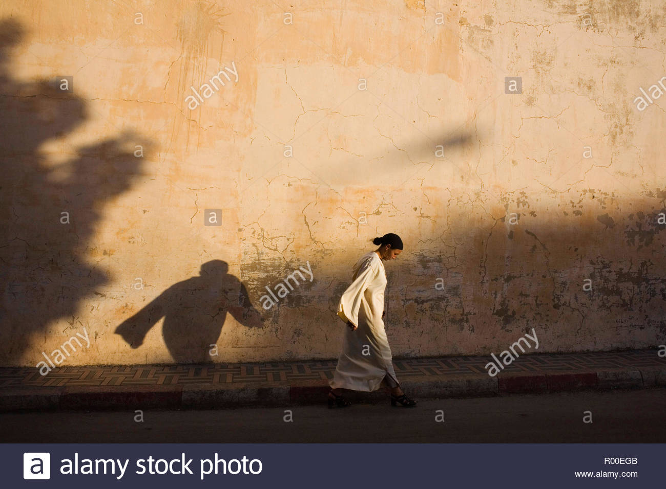 A Woman Walking Casting Her Shadow Of A Flowing Robe In The Early Evening Golden Light Stock Photo Alamy