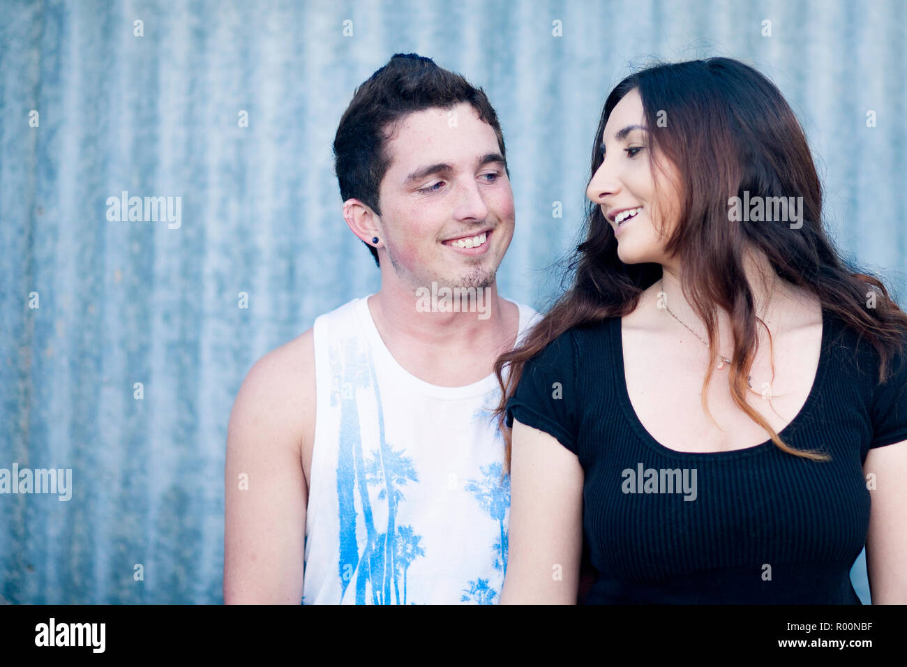 Teenage boy and girl standing close looking at each other smiling Stock ...