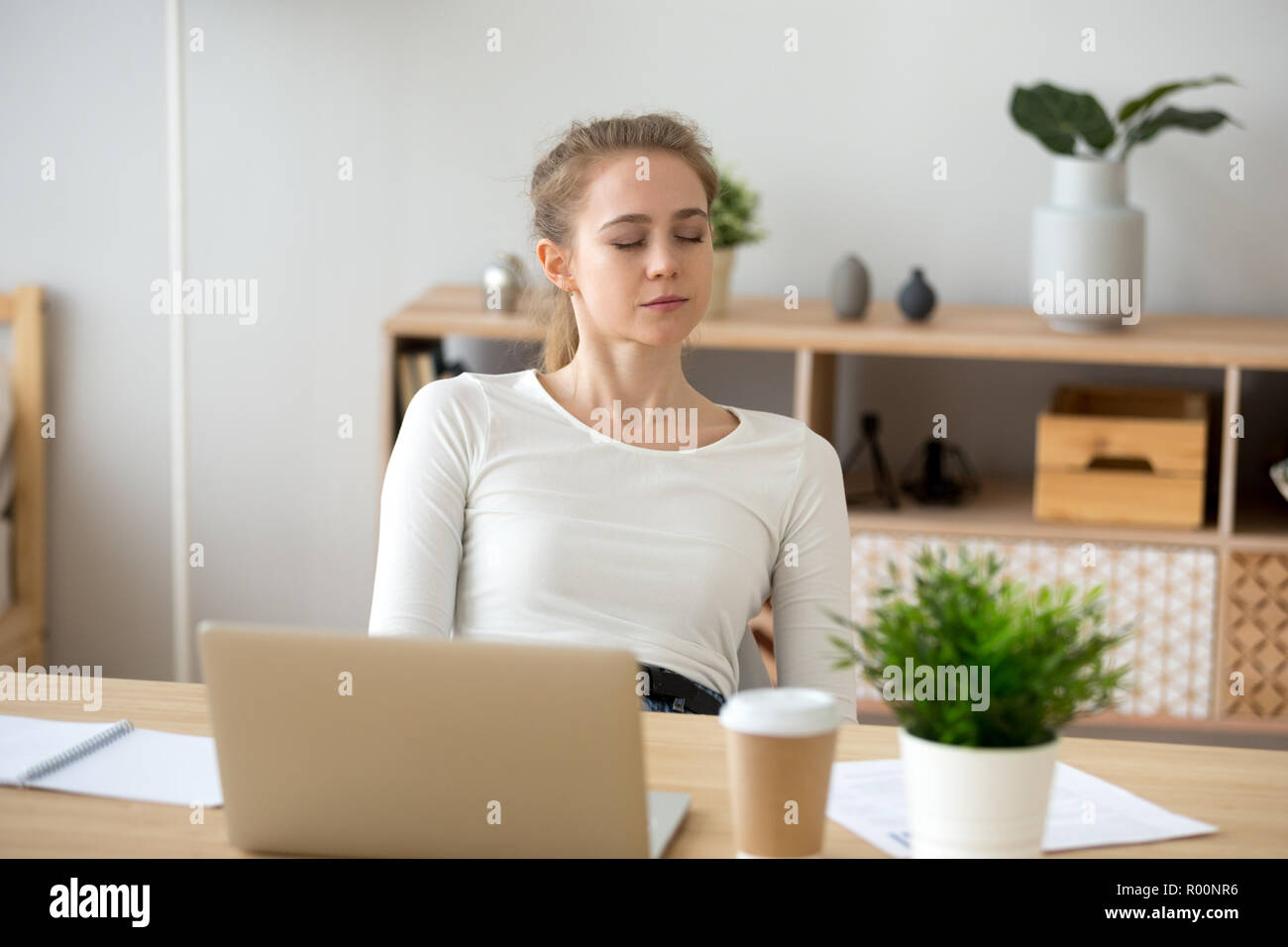 Woman sitting at the desk at office and sleeping Stock Photo