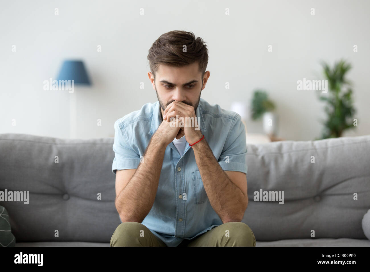 Serious pensive man sitting thinking at home Stock Photo
