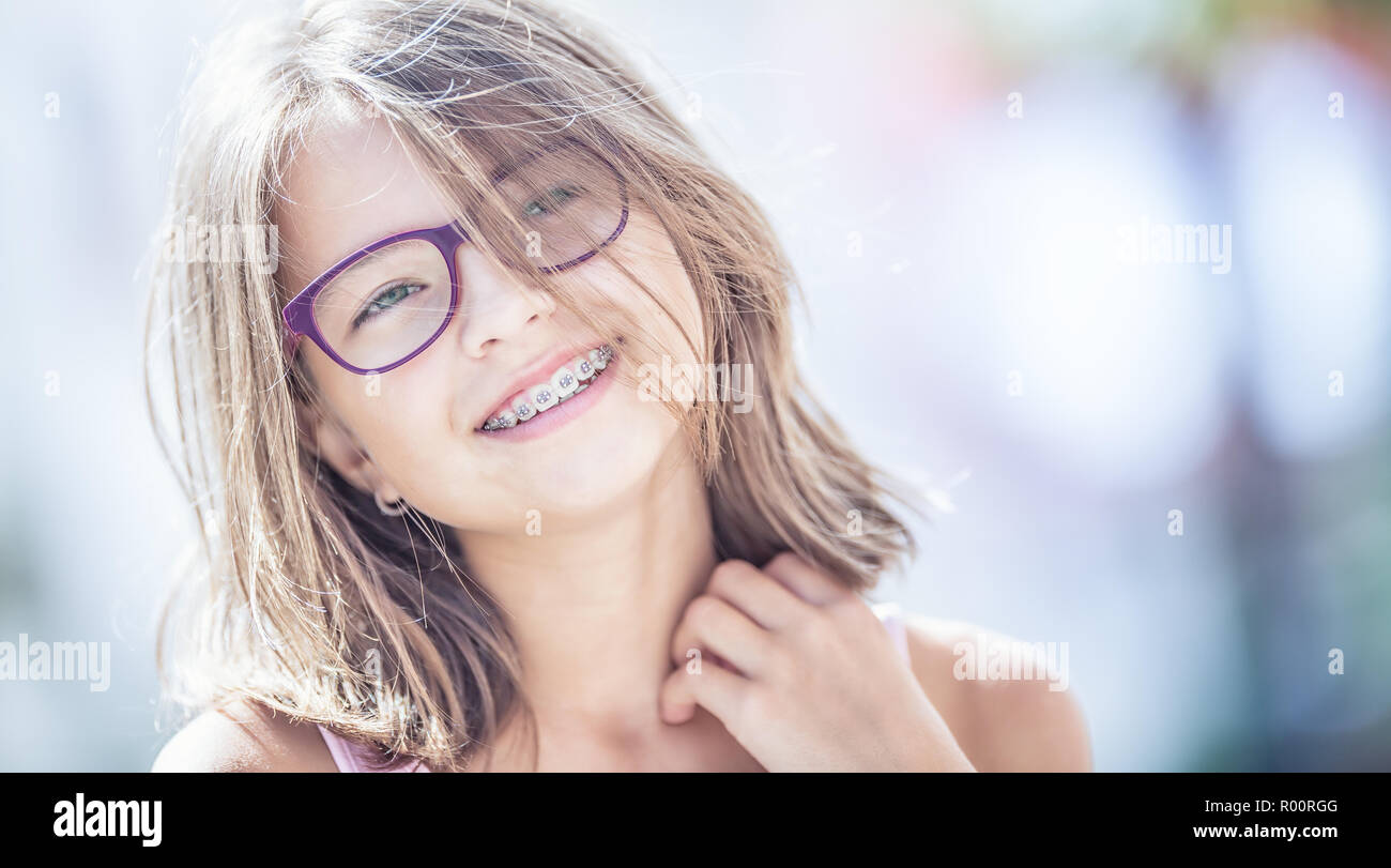 Happy smiling girl with dental braces and glasses. Young cute caucasian