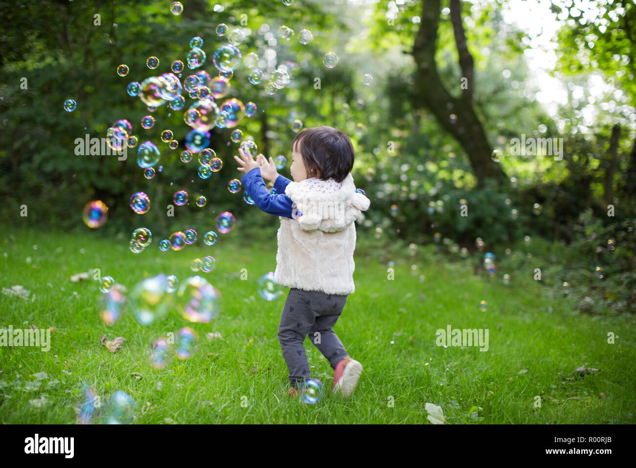 baby girl play bubble at Spring garden Stock Photo - Alamy