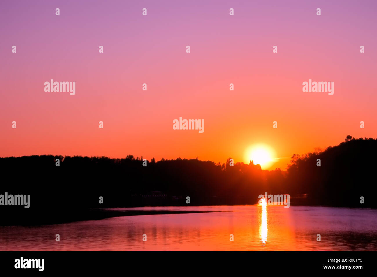 Sunset over lake. Setting sun on the cloudless sky Stock Photo