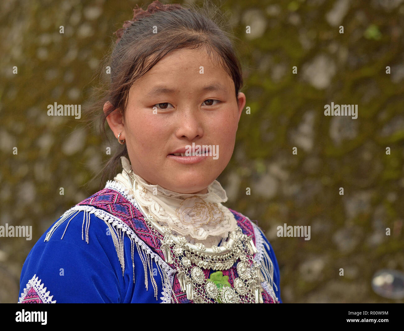 Young Vietnamese H’mong hill-tribe minority woman wears blue traditional H’mong clothing with a massive tribal silver necklace. Stock Photo