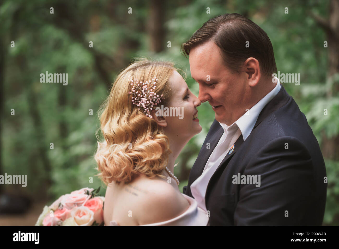 bride and groom kissing in the summer forest Stock Photo - Alamy