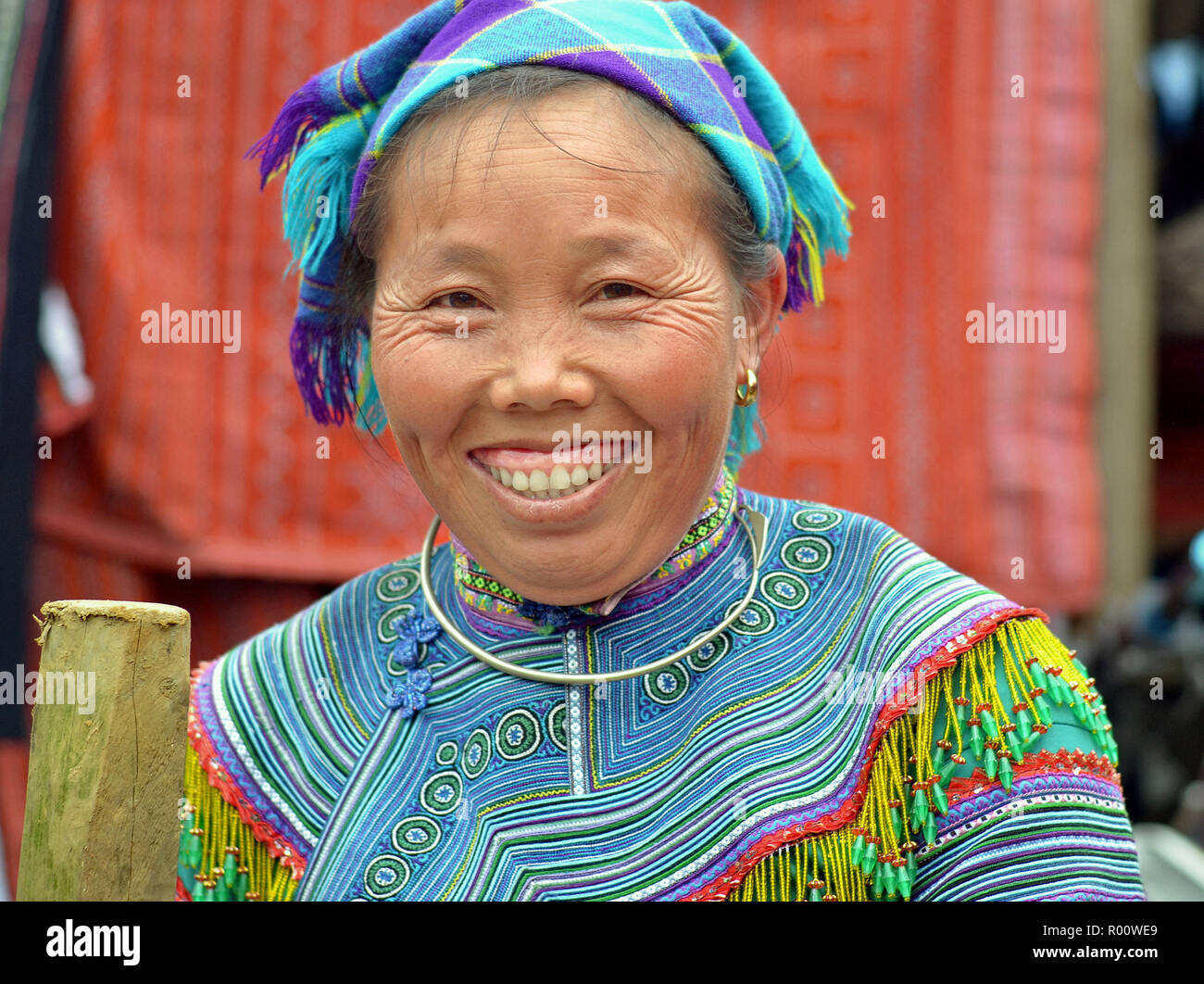 Middle-aged Vietnamese Flower H’mong ethnic-minority hill-tribe woman wears embroidered Flower H’mong traditional attire in blue Stock Photo