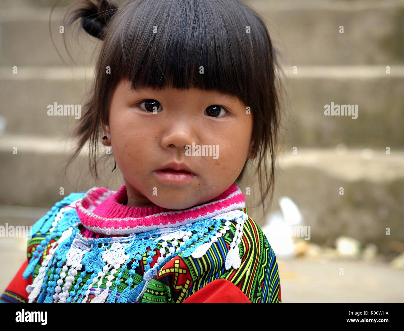 Cute Vietnamese H’mong ethnic-minority hill-tribe toddler girl with dirty face and snotty nose. Stock Photo