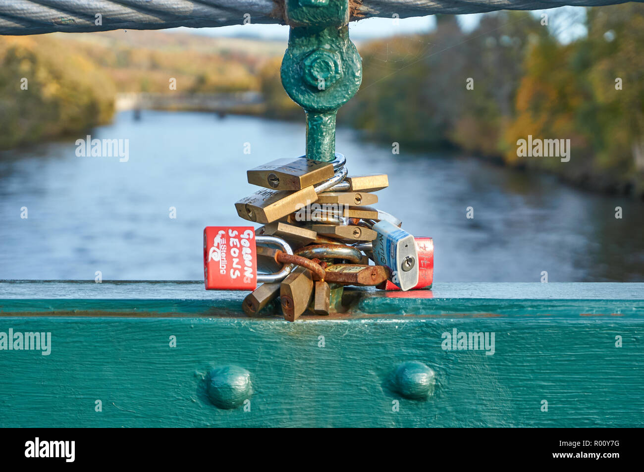 Padlocks locked onto an iron footbridge over the river Tummel in Pitlochry, symbolizing a love forever, Scotland Stock Photo