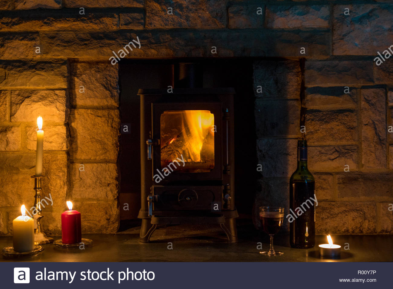 Hygge Concept A Log Burner Candles And A Wine Bottle And Glass