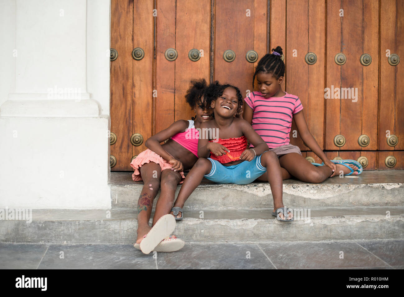 Some silly girls pose for the camera in a plaza in Havana, Cuba. Stock Photo