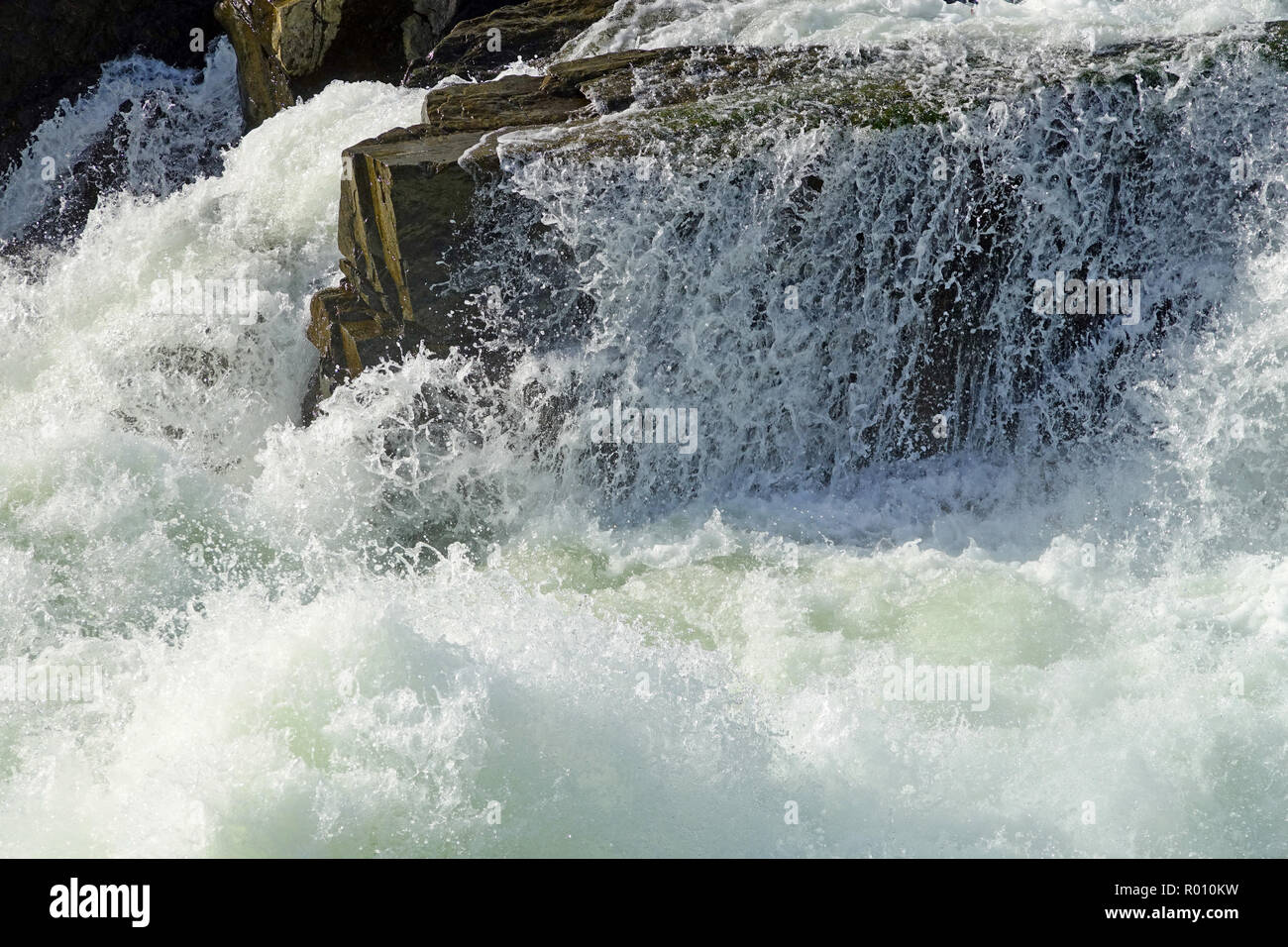rumbling waters surrounding rock at Great Falls Stock Photo