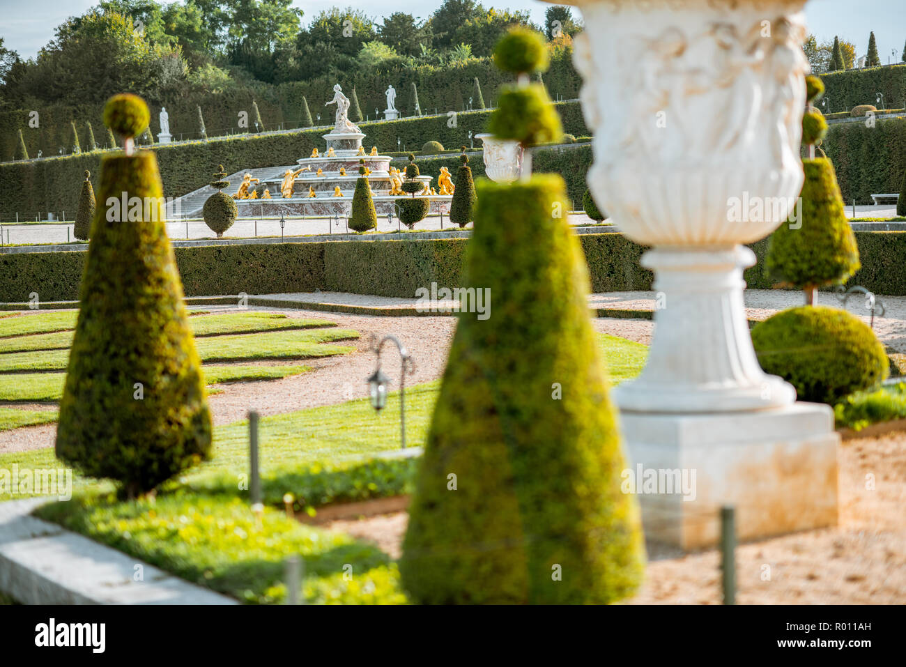 Versailles garden with beautiful sculptures, vases and trimmed bushes