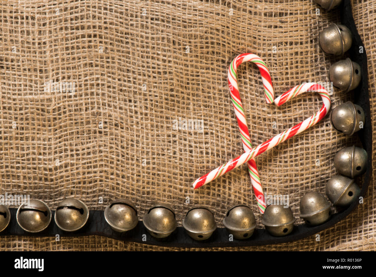 Antique sleigh bells and leather harness on burlap. Stock Photo