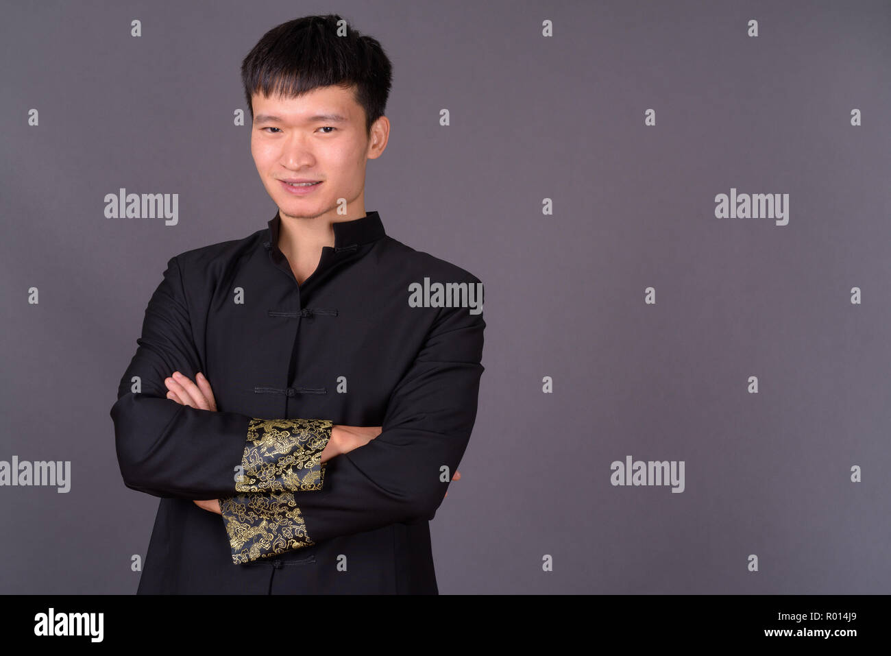 Studio shot of young Chinese man against gray background Stock Photo