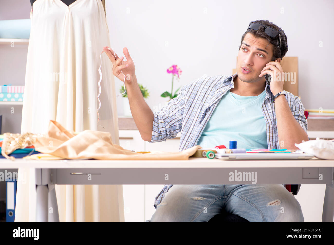 Young handsome tailor working in his workshop Stock Photo - Alamy