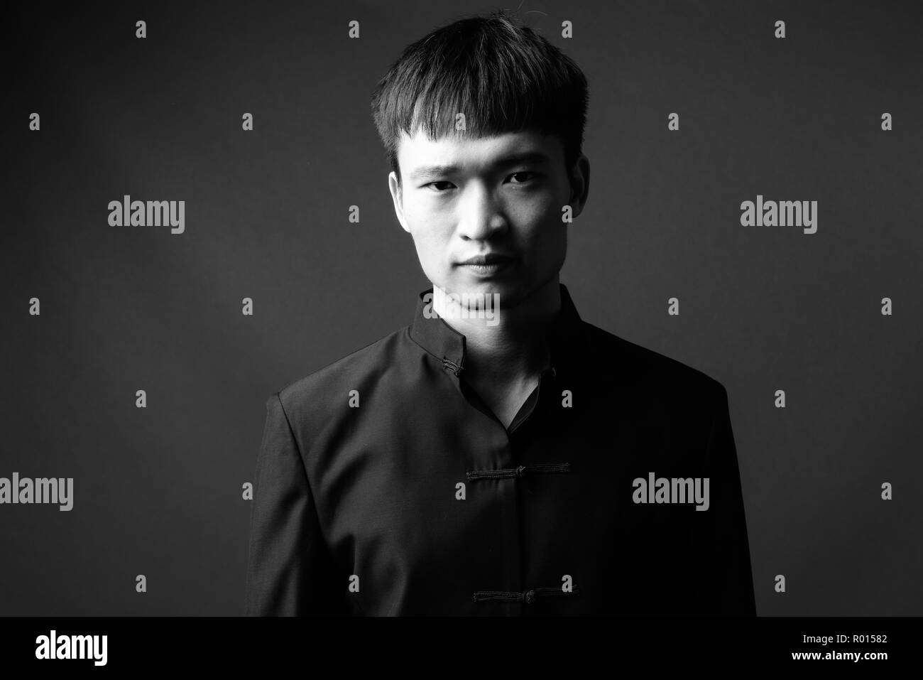 Studio shot of young Chinese man in black and white Stock Photo