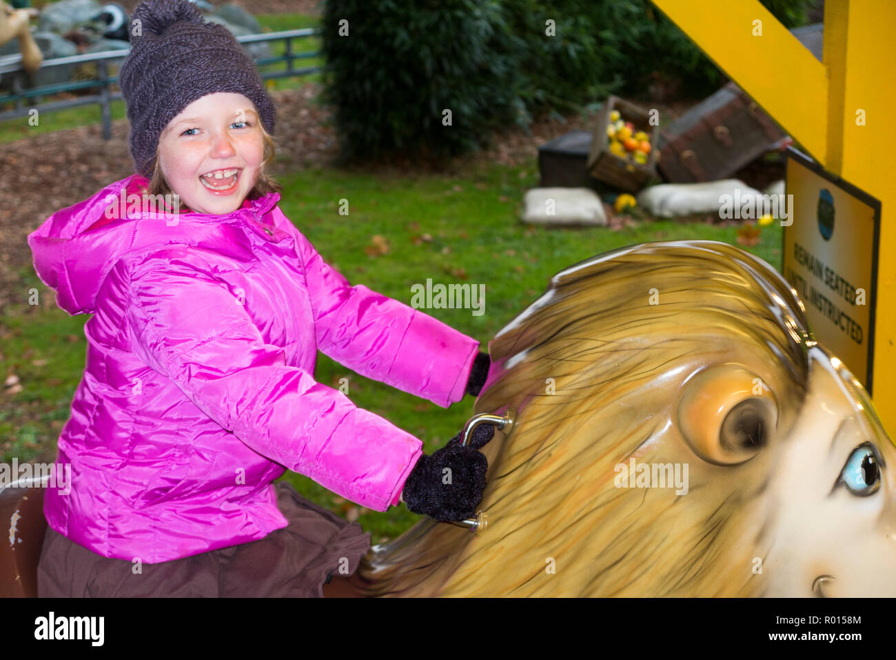 Young girl / child / kid / 6 years old / six year old riding on a lion