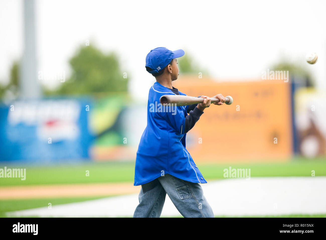 Young boy swinging a baseball bat on a playing field Stock Photo Alamy