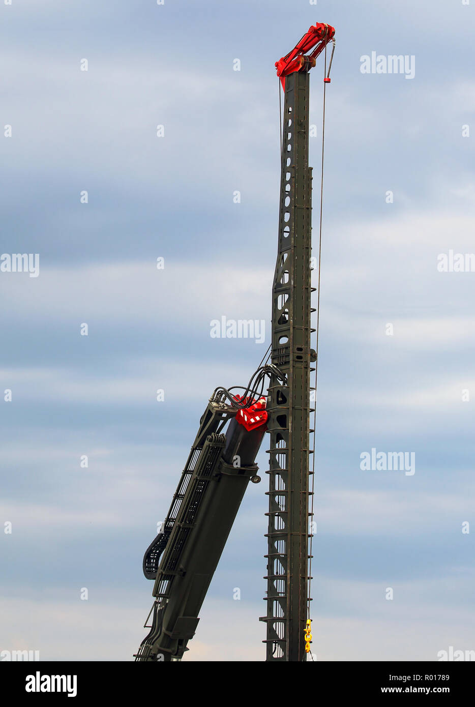 Crane boom with boring mast designed for lifting and installing a pile to the dive point when building foundations of buildings, drainage systems, dec Stock Photo