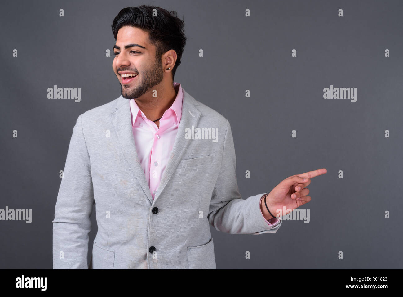 Young handsome Indian businessman against gray background Stock Photo