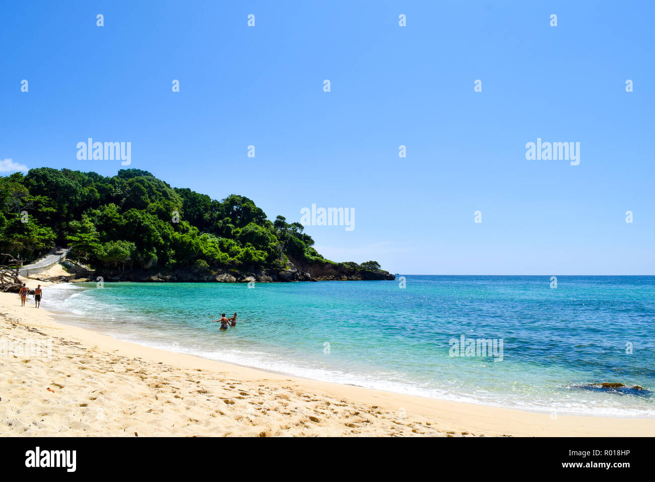 Paradise beach in caribbean sea, white beach, plams and turquoise ocean, some tourists at the beach in the dominican republic Stock Photo