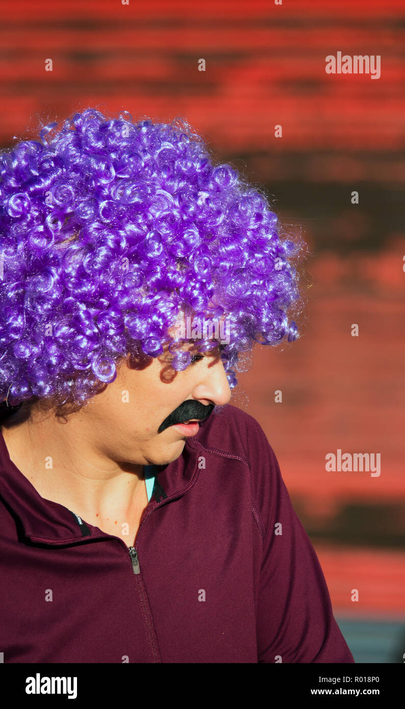 Stereotypical scouser in a curly purple wig ready to take part in the Scouse 5k fun run 2018 Stock Photo