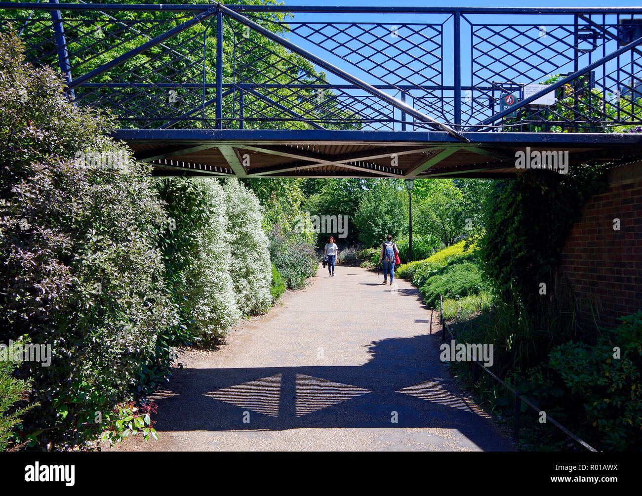 A beautiful, but unprepossessing, pedestrian footbridge carrying one footpath over another in Kensington Gardens, London Stock Photo