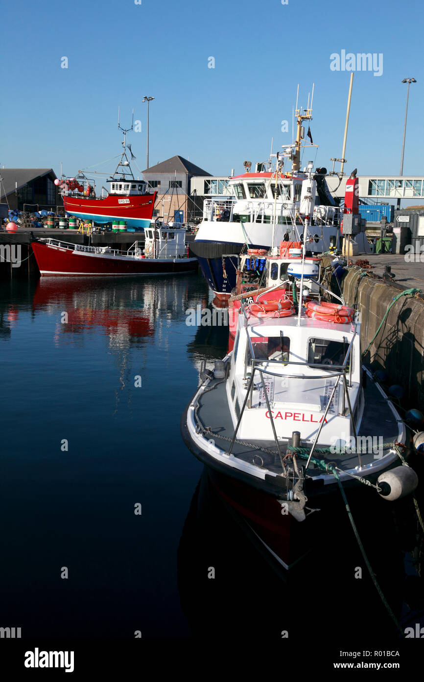 The harbour in Stromness, Orkney with fishing boats, the Hoy/Graemsay ferry centre right, and the ferry passenger footbridge Stock Photo