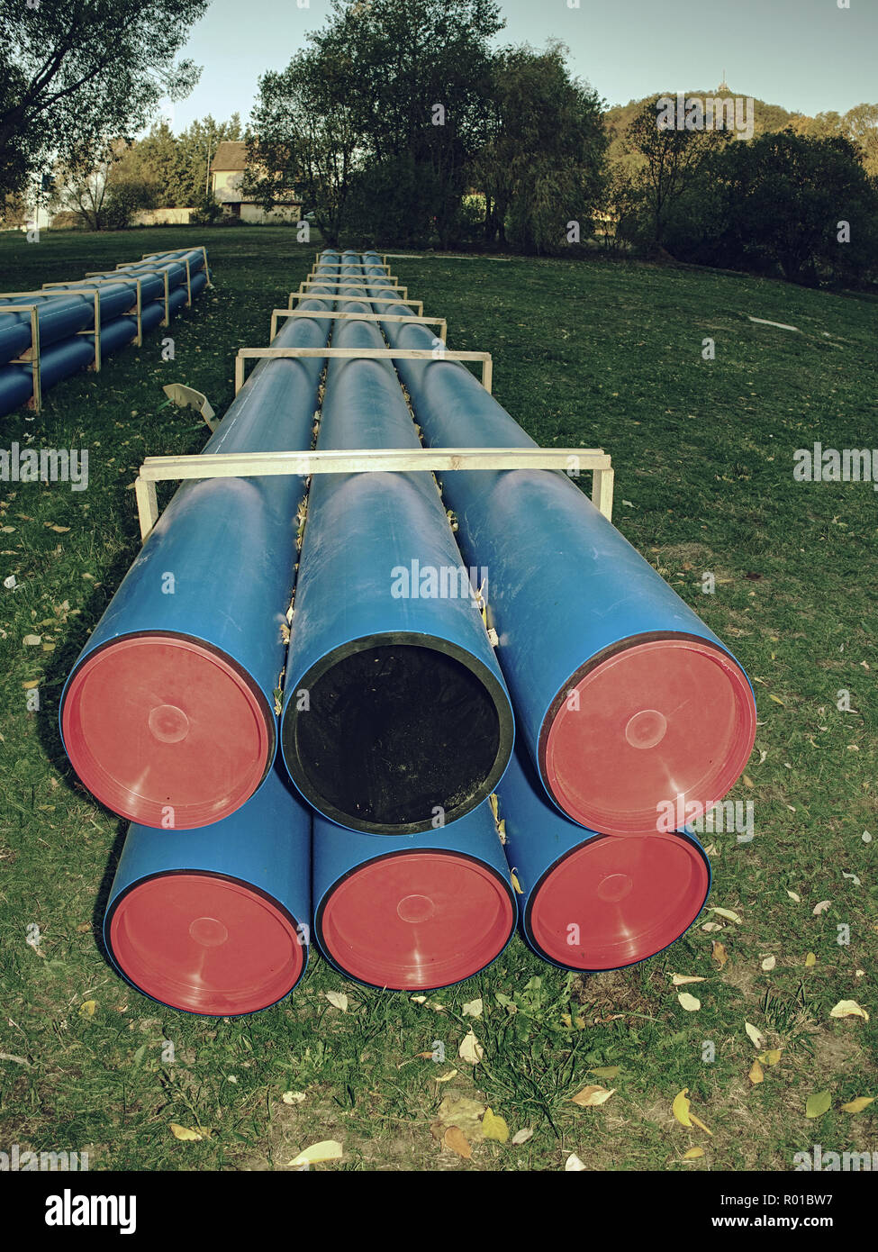 HDPE pipe for water supply stacked at building site on ground under the ...