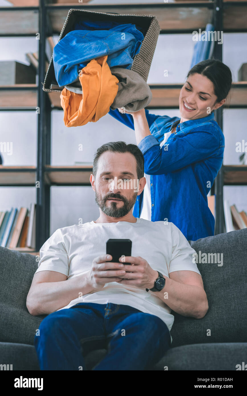 Joyful female person throwing clothes on husband Stock Photo Alamy