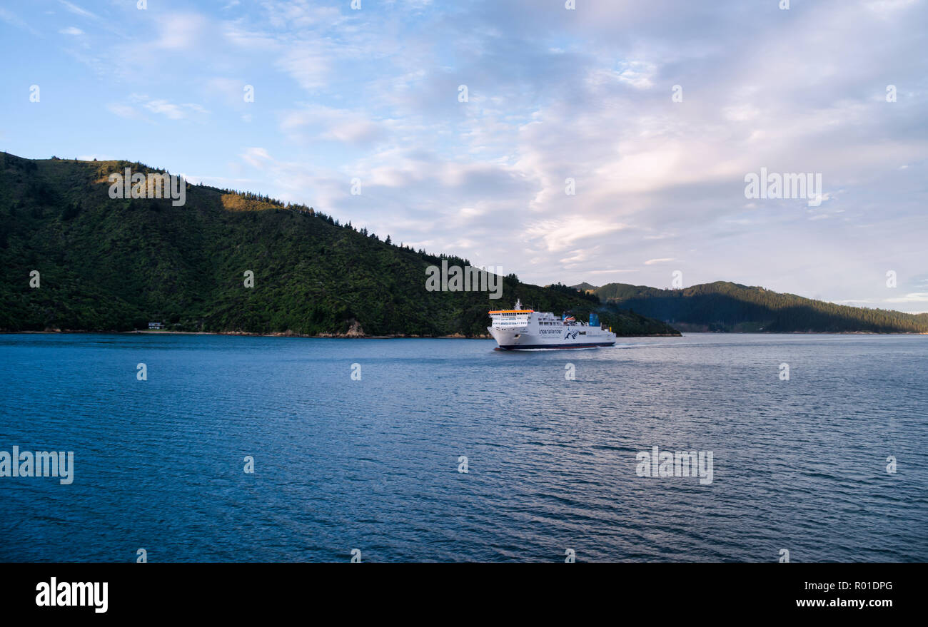 A ferry passes through the Marlborough Sounds of New Zealand on a calm autumn evening. Stock Photo