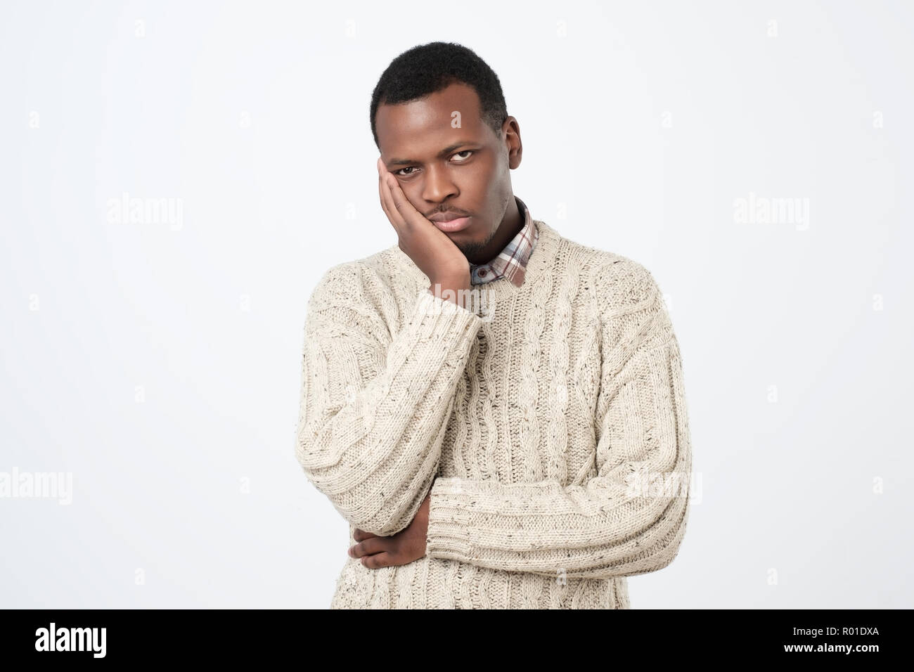 Boring, dull, tedious concept. Young african man looking at camera sadly Stock Photo