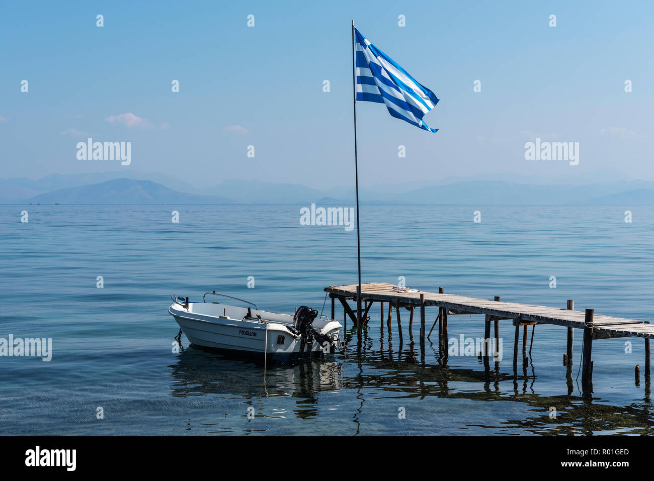 Boat, jetty, Greek national flag, Boukari, Corfu Island, Ionian Islands, Greece Stock Photo
