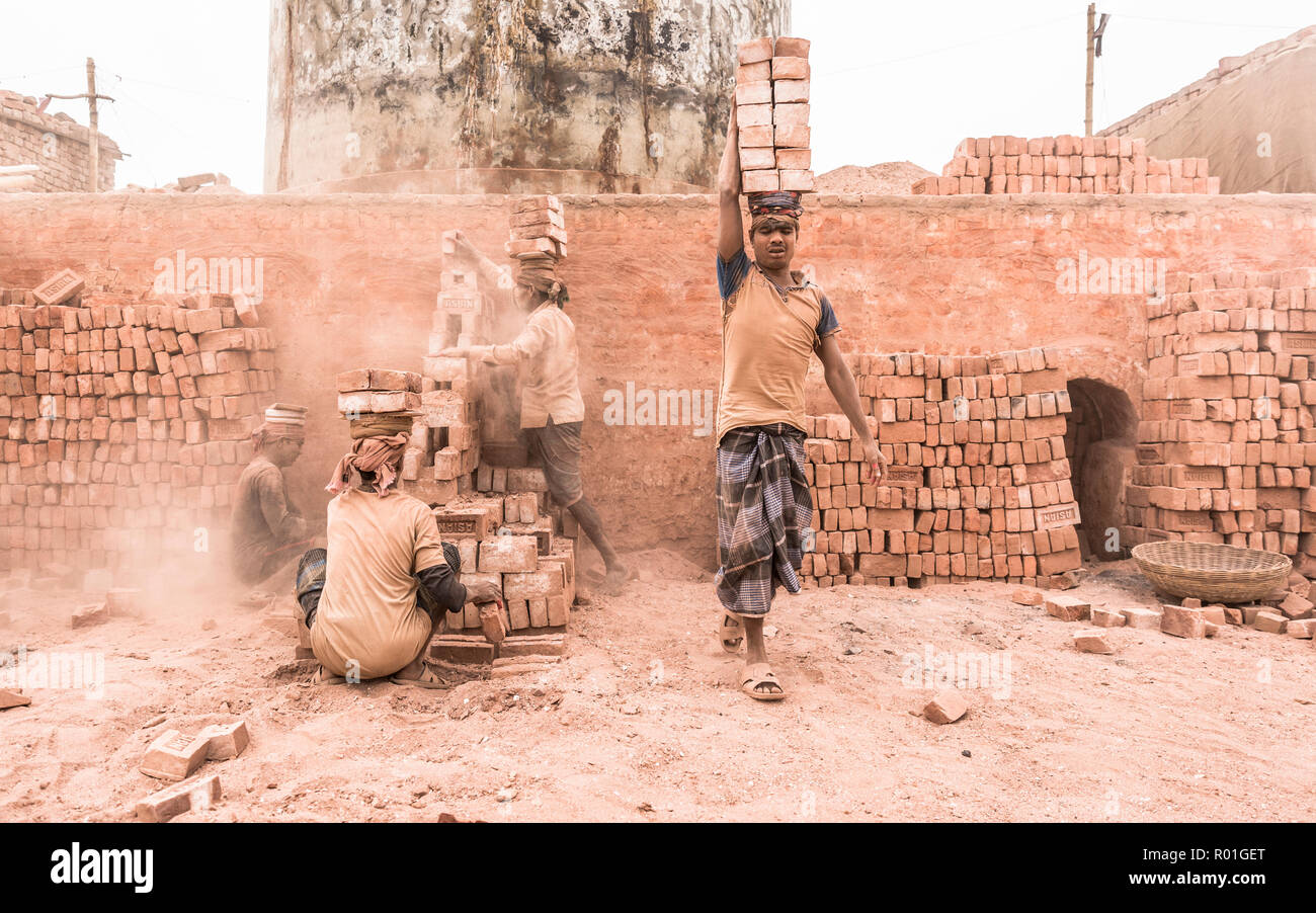 Workers with bricks on their heads in the brickyard, Dhaka, Bangladesh Stock Photo
