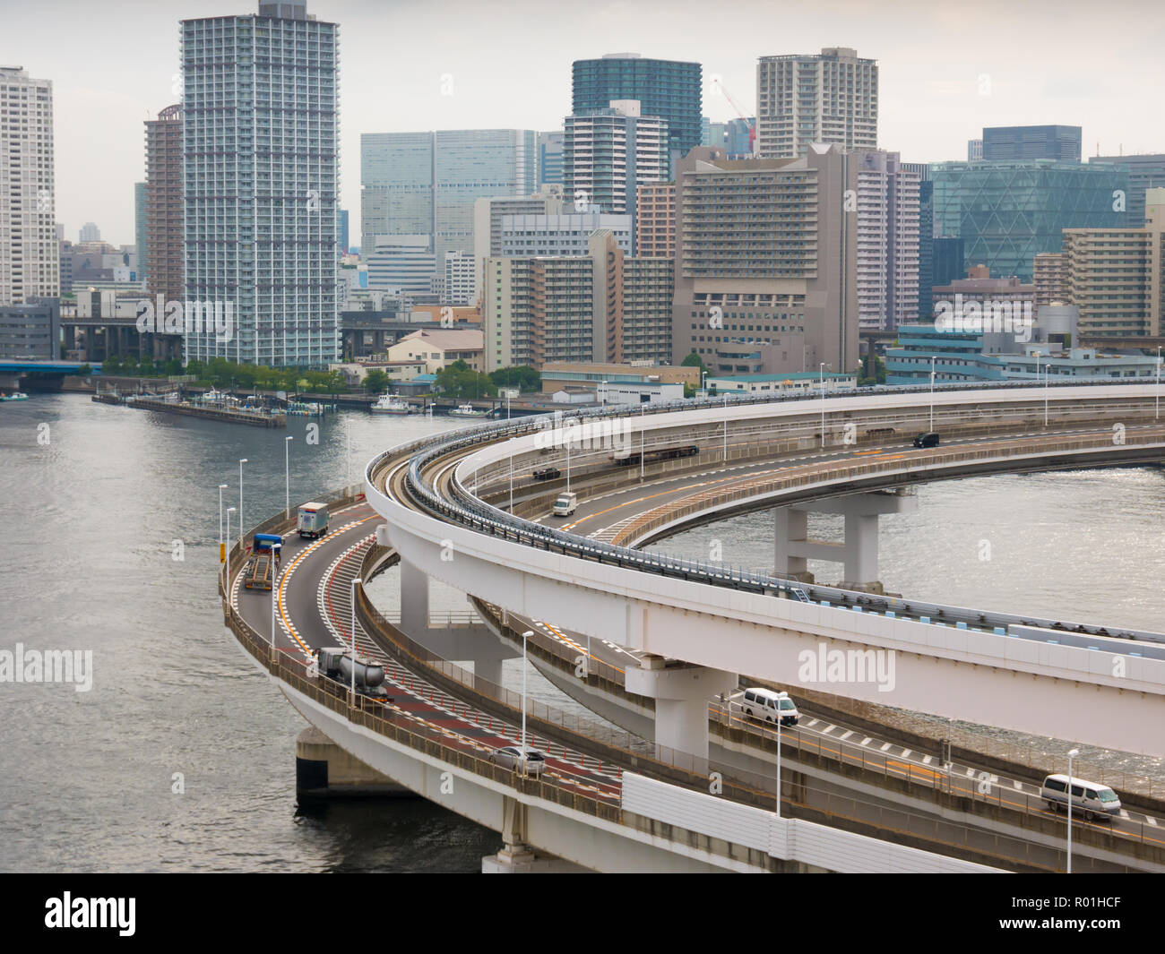 Modern highway with automobiles and train leading to a bridge. Rainbow bridge, Tokyo, Japan. Stock Photo