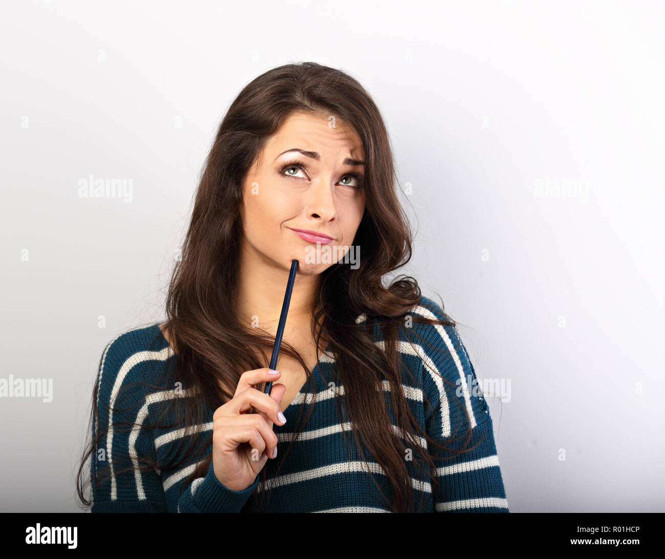 Confusion grimacing brunette woman thinking and looking up with pencil ...