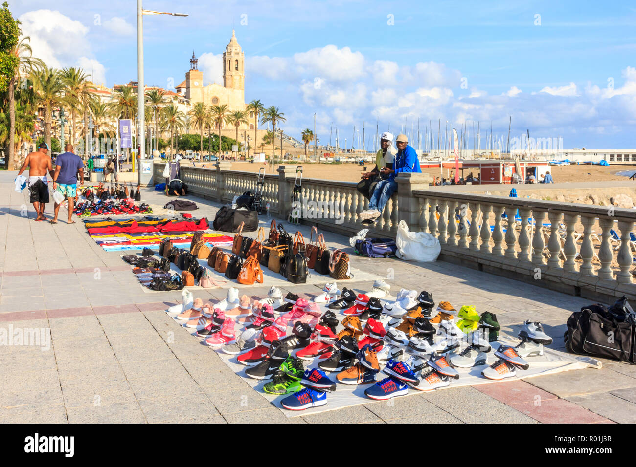 Sitges, Spain - 2nd October 2017: Africamn immigrant vendors selling their wares on the promenade. This is a common practice in Spain. Stock Photo