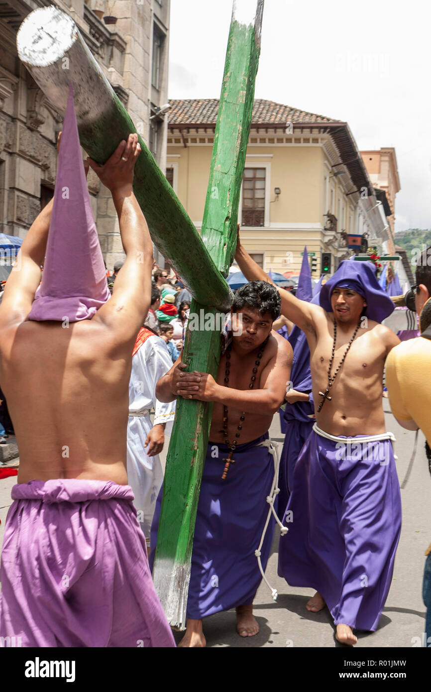 Quito, Ecuador - April 22, 2011: Unidentified man being carrying a heavy cross as penitance in a religious parade Stock Photo