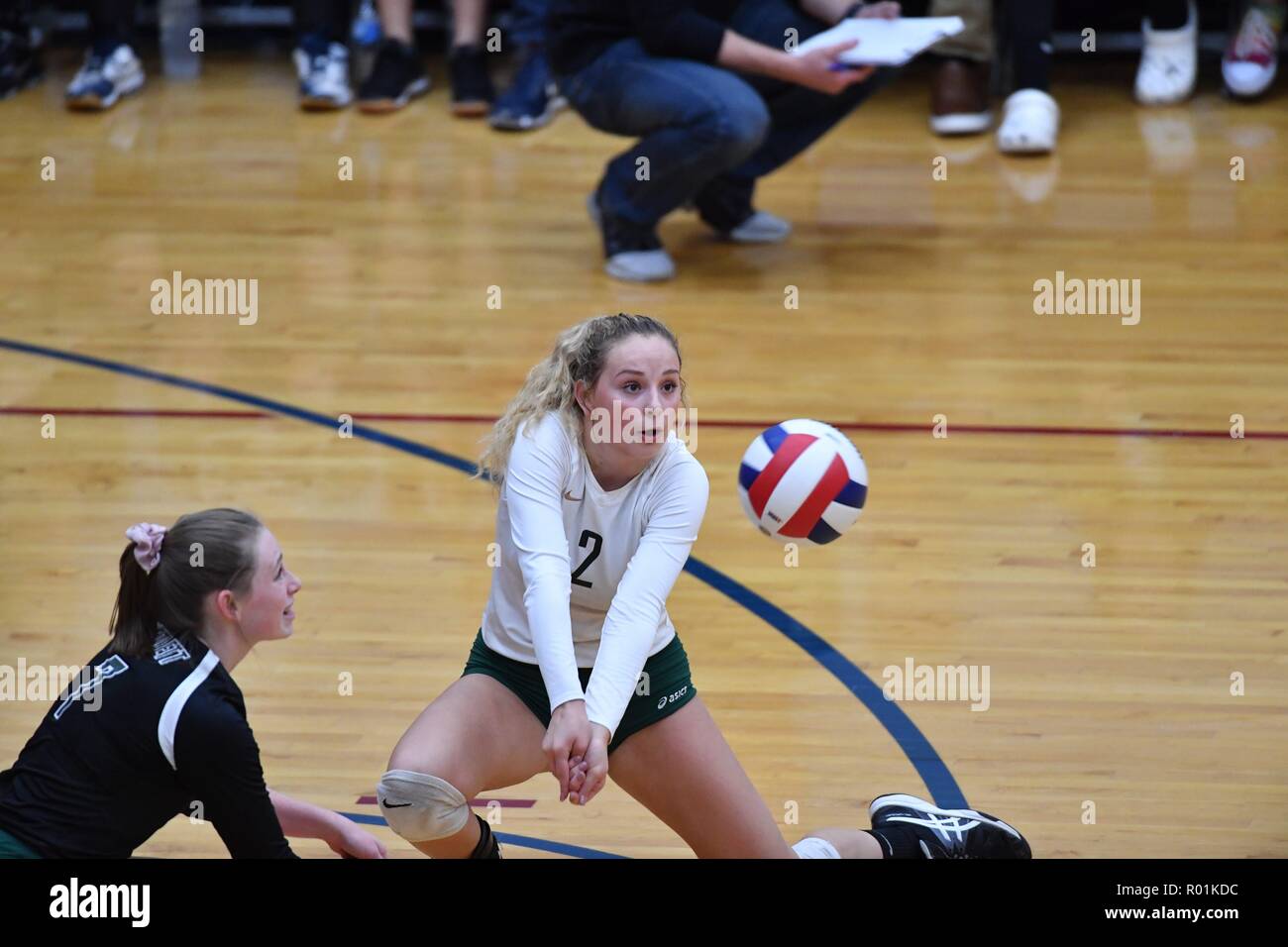 Player extending to the floor to dig out an opponent's shot. USA. Stock Photo