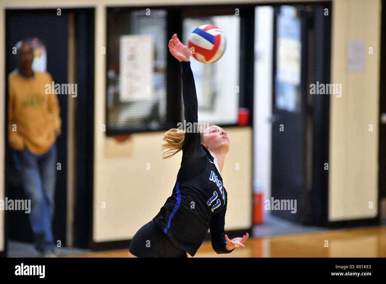 Player delivering a power serve during a high school match. USA. Stock Photo