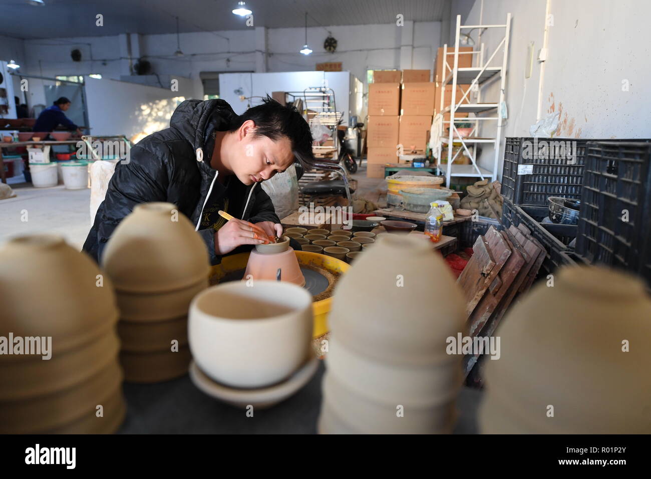(181031) -- JIANYANG, Oct. 31, 2018 (Xinhua) -- A craftsman polishes the body of a semifinished "Jian Zhan", a kind of black glaze bowl, at a workshop in Jianyang, southeast China's Fujiang Province, Oct. 29, 2018. "Jian Zhan", a kind of temmoku glaze or black glaze porcelain, was then used only by emperors of ancient China's Song Dynasty (960-1279). Famous for its nobility and gorgeousness, "Jian Zhan" was numerously exported overseas through the Silk Road on the sea. However, after Song Dynasty, those traditional firing techniques to make "Jian Zhan" failed to be handed down to future genera Stock Photo