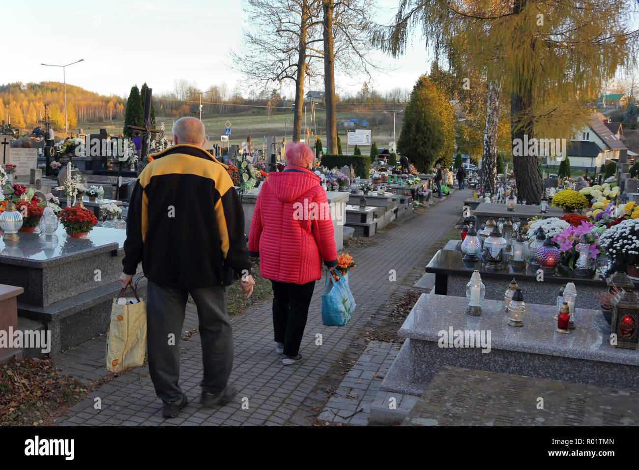ZACHELMIE, POLAND - OCTOBER 31, 2018: An elder couple carry flowers to be laid on graves in cemetery on the eve of All Saints' Day. Credit: Slawomir Wojcik/Alamy Live News Stock Photo