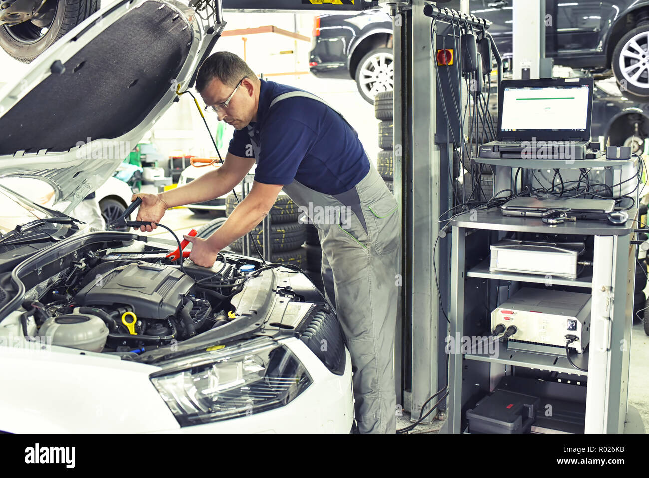 car mechanic charging the vehicle battery in the workshop Stock Photo
