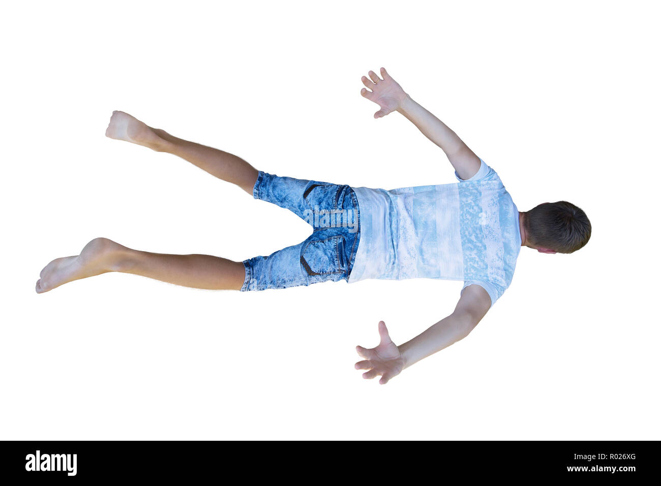 Rear view full length portrait of a young man free falling down hands and legs stretched isolated over white background. Stock Photo